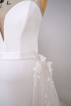 the back of a white dress with flowers on it