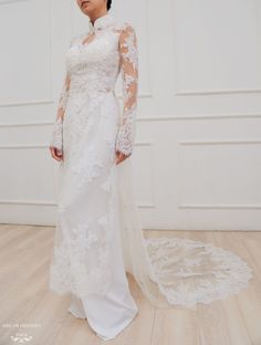 a woman in a wedding dress standing on a wooden floor