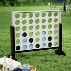 an outdoor game set up in the grass with bottles and plates on it, next to a picnic table