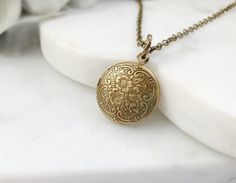 "This little locket necklace is made with a 15mm round, antiqued bronze floral locket, perfect to hold tiny photos, and it hangs on an 18-inch antiqued bronze cable chain with a lobster clasp. This lovely Victorian necklace makes the perfect romantic jewelry gift for her. Thank you for looking. NOTE: Gemsicles' gold-filled, rose/gold-plated, antiqued, silver and rhodium jewelry is cadmium-free, lead-free and nickel-free. Also, our plated jewelry is dipped in a special coating to help prevent tar Antique Brass Locket Necklace For Wedding, Antique Gold Locket Necklace In Brass, Bronze Brass Locket Necklace For Wedding, Antique Finish Brass Locket Necklace For Wedding, Bohemian Brass Locket Necklace, Bohemian Antique Gold Brass Locket Necklace, Vintage Adjustable Round Pendant Locket Necklace, Antique Adjustable Locket Necklace, Adjustable Vintage Round Pendant Locket Necklace