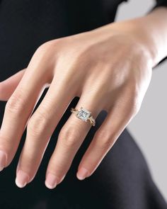 a woman's hand with a diamond ring on it