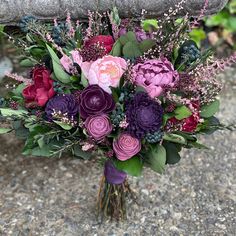 a bouquet of flowers sitting on top of a cement bench