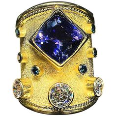 S.Georgios designer 18 Karat Solid Yellow Gold Ring all handmade with the Byzantine granulation workmanship and a unique velvet background all custom-made. The gorgeous ring has 1 Center Cushion Cut Tanzanite total weight of 4.45 Carats and 3 Brilliant cut White Diamonds total weight of 2.25 Carats. It also features 6 Brilliant cut Blue Diamonds - 3 on each side. This stunning ring is all custom made in our workshop in Athens Greece and is of outstanding workmanship and quality. It can also be o Most Expensive Jewelry, Thick Band Ring, Goth Wardrobe, Velvet Background, Funky Rings, Retro Band, Rings Boho, Blue Diamond Ring, Blue Diamonds