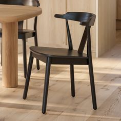 a wooden table and two black chairs in a room