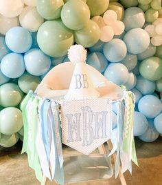 a baby's first birthday party with balloons and streamers on the wall behind it