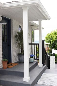 an instagram page on the front porch of a house with blue doors and white pillars