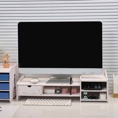 a computer monitor sitting on top of a white desk next to a keyboard and mouse