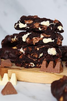 a stack of chocolate cookies sitting on top of a wooden cutting board