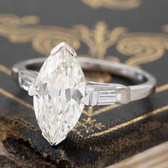 an old - fashioned diamond ring sits on top of a book