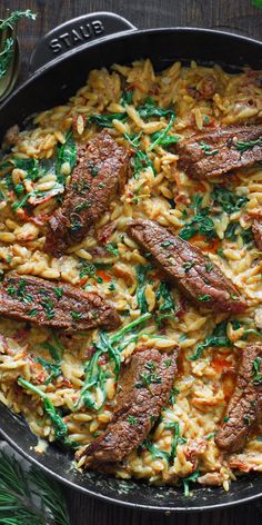 a skillet filled with pasta and meat