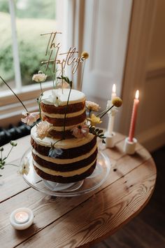 a three layer cake sitting on top of a wooden table