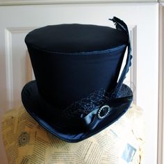 The Liza is a striking cabaret inspired full size top hat. It is covered with beautiful shiny black satin. It is decorated with black ribbon around the crown, black veil, half bow with black crystal buckle and two elegant black goose feathers. Also available as a medium size mini top hat: https://www.etsy.com/listing/256101614/victorian-witch-hatblack-mini-top?ref=shop_home_active_14 Need this TOP HAT in another color?Just send me a message to talk about a custom hat made just for you! This hat Black Gothic Hat For Costume, Vintage Top Hat For Costume Party, Vintage High Crown Top Hat For Costume Party, Vintage Top Hat With Curved Brim For Costume Party, Vintage Curved Brim Top Hat For Costume Party, Gothic Black Top Hat For Costume Party, Steampunk Costume Hat With Curved Brim, Black Gothic Top Hat For Costume Party, Gothic Top Hat With Short Brim For Halloween