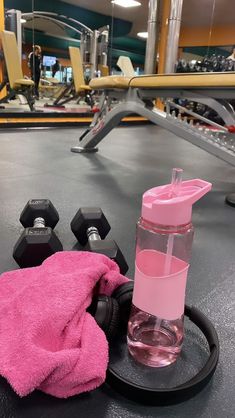 a pink towel and dumbs on a gym floor