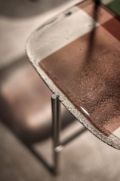 a close up of a glass table with metal legs