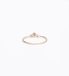 A slightly larger center and offset, delicate sides impart this delicate stacking ring with just the right amount of size and an unexpected silhouette. Though you can easily wear it on its own, you'll find a million ways to stack it thanks to the tiny space its curved design makes. Nestle it alongside other delicate rings for a multitude of sparkle or let it snuggle alongside a chunkier signet ring for maximum impact. Made in the U.S.A. Center setting measures 0.25" wide. 14 karat gold with thre Stackable Diamond Midi Rings With Round Band, Everyday Stackable Rings With Single Diamond, Everyday Stackable Diamond Ring With Round Band, Modern Stackable Diamond Midi Rings, Classic Stackable Rings With Bezel Setting, Open Ring Shape, Everyday Stackable Rose Cut Diamond Rings, Minimalist Stackable Rings With Round Diamond Band, Minimalist Diamond Stackable Rings With Round Band, Minimalist Adjustable Rings With Smooth Bezel