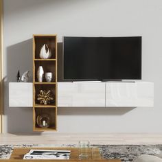 a living room with a large television on top of a wooden entertainment center next to a coffee table