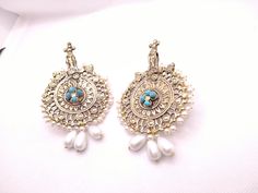 * This astonishing pair earing is a classical ornament, embellished with various elements and fine work. * The Bohemian inspired earrings feature craved motifs, Feruza stones and tinny dangling white beads. * The huge sized earrings would complete your stylish look and would add a pinch of ethnic touch to your modish look. * We assure you the High-Quality Product with On Time Delivery * White Intricate Design Danglers As Gift, Traditional Pierced Bridal Drop Earrings, Traditional Bridal Drop Earrings, White Intricate Danglers For Gift, White Danglers With Intricate Design For Gift, Festive Chandbali Pierced Earrings, Intricate Drop Earrings For Festivals, Traditional White Pearl Earrings, Traditional White Pearl Pierced Earrings