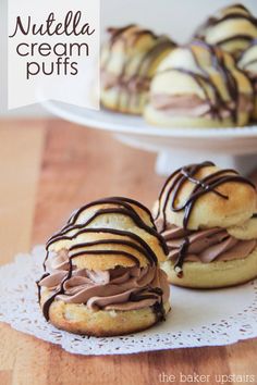 chocolate cream puffs are sitting on a doily