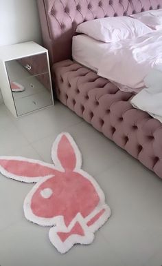 a bed with a pink bunny rug on the floor