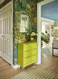 a living room with green and yellow wallpaper on the walls next to a door