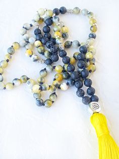 This mala necklace is made with 108 natural stone beads of yellow jasper and lava stone of 6 mm diameter and adorned with silver beads. This prayer garland  is the perfect support garland for counting mantras during your practices. Its a 108 knotted beads mala, very light weight, an spiritual sacred jewelry for chakra healing. I make each mala by hand, knotting each of the 108 beads with great care and I made every single silky and delicate tassel. I use a very resistant braided macrame rope, achieving a mala that lasts over time. All our malas are very versatile, since you can use them on many occasions. These products are not intended to treat, cure, or prevent any disease. They should be used as a spiritual support during healing. The results are unique to the user. Spiritual Stone jewe Yellow Spiritual Jewelry With Gemstone Beads, Spiritual Yellow Gemstone Beads Jewelry, Spiritual Yellow Jewelry With Gemstone Beads, Yellow Spiritual Beaded Necklace With Gemstone Beads, Yellow Hand-strung Jewelry For Meditation, Silver Beaded Necklace For Meditation With 8mm Beads, Spiritual Yellow Necklaces For Meditation, Yellow Beaded Jewelry For Meditation, Spiritual Yellow Hand-strung Necklaces