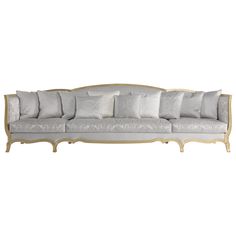 a white couch with lots of pillows on it's back and side panels,