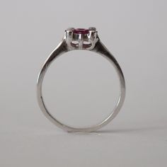 This piece is a wonderful solid white gold ring. It is also a new vintage- made before 2001. The ring is brilliantly decorated with 4 genuine princess cut Chantaburi rubies from Thailand in the middle and on the sides are 4 tiny round cut natural diamond. Only one left- once its gone its gone! Product Details: Metal: 18k Solid Gold Metal Color: White Gold Gold weight: 3.10 grams Ruby: Natural, princess cut, 0.65 carats Diamonds: Natural, round faceted cut, 0.08 carats Band Width: 7 mm #Customiza White Gold Ruby Ring In Platinum, Vintage Emerald-cut Amethyst Ring For Anniversary, Vintage Emerald Cut Amethyst Ring For Anniversary, Vintage Ruby Rings With Polished Finish, Classic White Gold Emerald Cut Amethyst Ring, Classic Polished Heart Ring For Wedding, Classic Sapphire Ring Gift, Classic Emerald Cut Amethyst Ring, Classic Emerald-cut Amethyst Ring