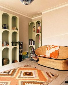 a living room filled with furniture and bookshelves next to a rug on the floor