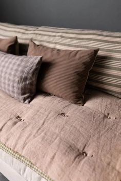 a bed with four pillows sitting on top of it's headboard and bottom end