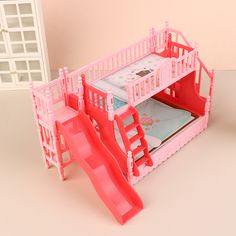 a pink doll house with a slide and bunk bed