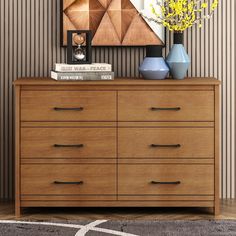 a wooden dresser with two vases on top of it