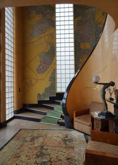 a spiral staircase in an elegant home with yellow walls