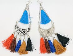 Brown, Blues, Orange colors make for a fascinating earrings.  These fashion drop dangle tassel earrings are silver-tone earrings with intricate carving on the circular metal and multicolor thread bells on the bottom forming the body of the earrings. #tlb #bohogift #Indian #Handmade #tasselearring #gypsytasselearrings Dangle Tassel Earrings For Festivals, Festival Tassel Dangle Earrings, Traditional Tassel Chandelier Earrings For Festival, Silver Tassel Earrings For Festivals, Blue Metal Earrings With Latkans, Silver Bohemian Tassel Earrings For Festival, Metal Tassel Earrings For Festival, Tassel Metal Earrings For Festival, Bohemian Metal Chandelier Earrings With Tassels