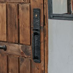 a close up of a wooden door with a metal handle on the front and side