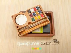 a wooden box filled with different types of art supplies