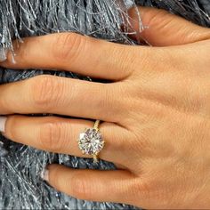 a woman's hand with a diamond ring on it