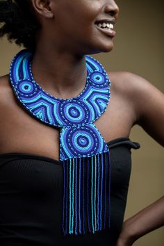 Unique Africa Maasai Handcrafted Leather Beaded Necklace with an Elegant Look and Brilliant Finish. Color = Different shades of blue. Length (Around Neck) =Adjustable. Length ( Downwards ) = 14 Inches / 37 Centimeters. **GET FREE SHIPPING FOR ADDITIONAL ITEMS PURCHASED. Yes, Buy Multiple Items and pay shipping for 1 item only- The rest ships Free. (No Limits on the number of Multiple items). With a faster delivery time of 3 days via DHLExpress, Worldwide. Ordinary/Standard Shipping also availabl Bohemian Blue Beaded Necklace, Artisan Blue Beaded Necklaces, Blue Necklaces With Black Beads For Festival, Blue Necklace With Black Beads For Festival, Blue Beads For Festivals, Blue Round Bead Necklaces As Fashion Accessory, Blue Round Bead Necklaces, Artisan Blue Beaded Chain, Blue Necklaces With Round Beads As Fashion Accessory