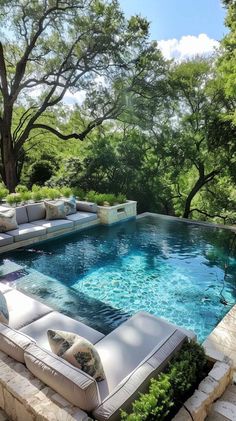 an outdoor living area with couches and a swimming pool in the middle of it