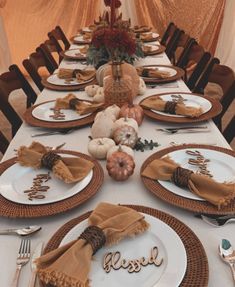 a table set for thanksgiving dinner with pumpkins and gourds