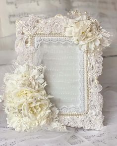 a white lace frame with flowers on it