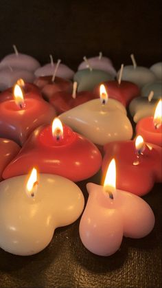 many lit candles are arranged in the shape of hearts