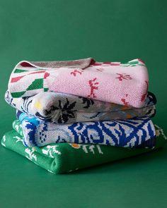 three folded towels sitting on top of each other in front of a green background,