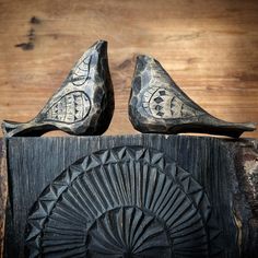 pair of carved wooden shoes sitting on top of a piece of wood