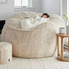 a woman is sleeping in a bean bag chair