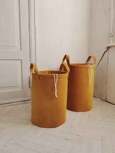 two yellow baskets sitting next to each other on the floor