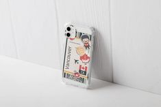 an iphone case sitting on top of a white table next to a wooden paneled wall