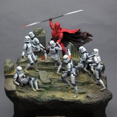 star wars figurines posed on top of a rock with swords in their hands