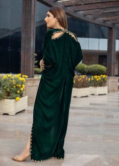 Deep forest green Velvet Kaftan delicately handworked with dabka, nakshi and zardozi on the neckline, shoulder slits, sleeves and front and back hemline and side slits. Festive Green Dabka Kaftan, Evening Anarkali Gown With Cutdana, Green Kaftan With Resham Embroidery For Festive Season, Green Embellished Floor-length Kurta, Green Embellished Kurta With Traditional Drape, Green Zari Work Kaftan For Festivals, Green Kaftan With Resham Embroidery For Festive Occasions, Embellished Green Kurta, Green Festive Kaftan With Resham Embroidery