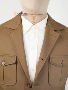 This custom brown cotton safari jacket features button closure and patch pockets, blending functionality with style. Ideal for travel, business, or formal occasions, it offers a rugged yet refined look. A perfect gift for men who appreciate versatile, tailored attire. At Magnate Artisans, we believe that fashion is an art form, and your wardrobe is a canvas. Our custom-made clothing service is designed to bring your unique vision to life, offering an unparalleled level of personalization for bot Dapper Suits, Hunting Jacket, Mens Travel, Hunting Jackets, Custom Made Clothing, Safari Jacket, Bespoke Tailoring, Travel Business, Business Formal