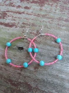 These beaded hoop earrings feature a turquoise bead and peachy colored seed beads. Pink Tiny Beads Hoop Earrings, Pink Hoop Beaded Earrings With Tiny Beads, Trendy Pink Hoop Earrings With Round Beads, Pink Round Beaded Earrings With Dangling Beads, Pink Beaded Hoop Jewelry, Pink Earrings With Tiny Beads, Pink Hoop Earrings With Colorful Beads, Pink Hoop Earrings With Tiny Beads, Bohemian Pink Hoop Earrings With Round Beads